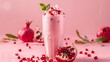 A vibrant pink smoothie adorned with juicy pomegranate seeds on a matching pink background