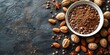 Cocoa powder in a bowl with nuts on a dark background.
