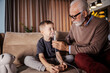 © Dusan Petkovic - A grandfather is using a nebulizer and helping a grandchild with inhalation.