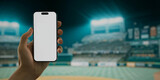 Fototapeta  - A hand holds a smartphone with a green screen at a baseball stadium