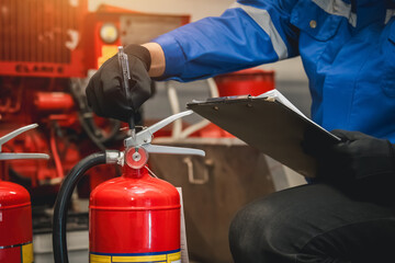 Engineer check fire extinguisher tank in the fire control room for safety in factory or industry.