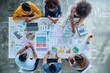© Ifti Digital - A diverse group of individuals gathered around a table, engaged in discussions and working on documents, Overhead view of a strategic planning session with charts and figures, AI Generated