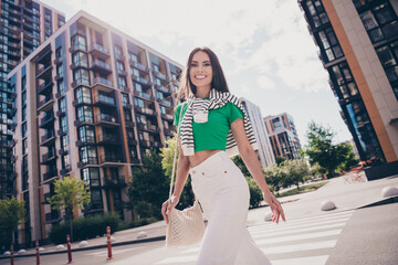 Poster - Photo of attractive young charming beautiful happy girlfriend bring handmade handbag enjoy weekend walking outdoors city between buildings