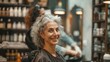 Joyful woman with curly grey hair at hair salon.