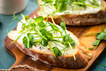 Wall Mural - Toast with micro greens, green pea and cream cheese at blue. Healthy food snack, vegetarian.