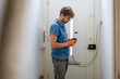 © Image Source - A focused technician working on electrical wiring at home.