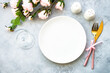 Table setting with white plate, cutlery and wine glass with rose flowers. Table decor for an anniversary or wedding. Flat lay with copy space.