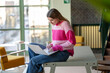 © Image Source - Young woman focused on her laptop in a modern study area.