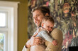 © Connect Images - Loving father holding his sleepy baby in a warm embrace at home