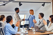 © bnenin - Two clients doing a handshake after finishing a meeting with other colleagues.