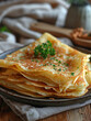 Stack of thin pancakes with parsley on plate. Vertical banner 3:4