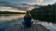 Woman meditating on a pier at sunset by the lake