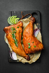 Wall Mural - Baked chicken legs on a wooden board. Grilled chicken, grilled chicken legs. On a dark background.