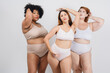 portrait of three beautiful multiracial latin women with natural bodies posing in underwear with white background