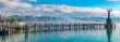 Lovely large panorama of the pier leading to the famous Imperia statue at the harbour entrance of Constance (Konstanz) by Lake Constance (Bodensee) in Germany on a spring day with blue sky. 
