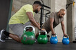 © ReeldealHD images - Personal trainer with African American mature male using kettlebells for a workout