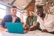 © Monkey Business - Three Businessmen Meeting In Modern Office Sitting Around Table Working On Laptop Together