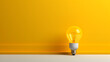 © Janina - An illuminating lightbulb centered against a vibrant yellow backdrop symbolizes creativity and inspiration