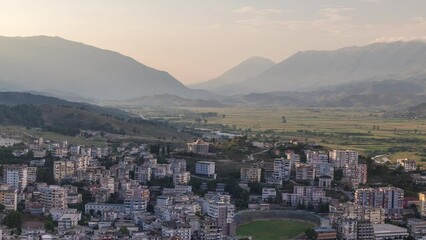 Sticker - Gjirokastra city from the viewpoint of the fortress of the Ottoman castle of Gjirokaster timelapse. Albania aerial view during sunset with moving shadows over typical houses