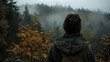 © Rudsaphon - Young Hiker Contemplating Misty Autumn Forest on Mountain Peak with Beanie and Backpack