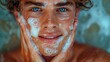 Young handsome man putting facial foam on his face and smiling at the camera