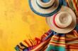 Two straw hats are on a yellow background. The hats are red and blue. The background is yellow and has a striped pattern