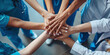© Oleksandr - Various medical professionals place their hands together in a gesture of unity and teamwork.