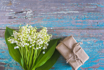 Wall Mural - Happy May Day concept; Bouquet of lilies of the valley and handmade gift box on a old blue paint wooden background; copy space