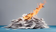 A pile of paper on fire over a blue background