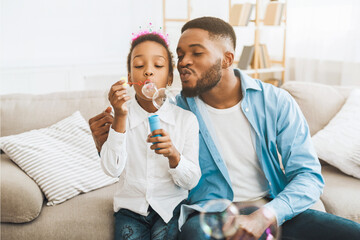 Wall Mural - Afro Dad And Daughter Blowing Soap Bubbles