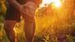 Closeup of young woman with knee pain while running at sunset. Health care and medical concept.