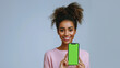 Photo of a woman holding up a phone with a green screen, white background, a stock photo