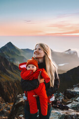 Wall Mural - mother walking with infant baby in mountains outdoor family travel lifestyle scandinavian woman with