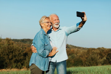 Wall Mural - woman man outdoor senior couple happy lifestyle retirement together smiling love selfie camera matur