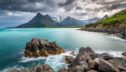 Wall Mural - Rocky mountain in the water. Blue ocean. Cliff coast. Beautiful seascape. Dramatic gray blue sky.