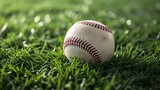 Fototapeta Zachód słońca - A close-up image of a baseball resting on a lush green field. The ball is made of leather with red stitching and has a slightly worn appearance.