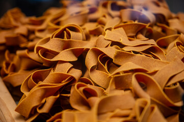 Wall Mural - Italian food, dried handmade colorful pasta pappardelle with saffron, ready to cook, Milan, Lombardy, Italy