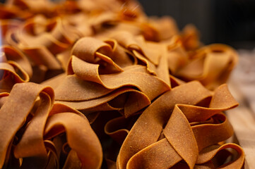 Wall Mural - Italian food, dried handmade colorful pasta pappardelle with saffron, ready to cook, Milan, Lombardy, Italy