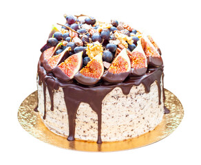 Wall Mural - Delicious cake with figs dipped into melted chocolate, pecan nuts, grapes, chocolate bites and cookies on the top on rustic background