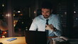 © stockbusters - Distressed businessman looking computer worried problem at night office close up