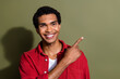 Photo of positive good mood guy wear red shirt showing finger empty space isolated khaki color background