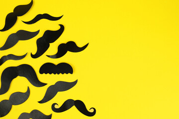 Wall Mural - Fake paper mustaches on yellow background, flat lay