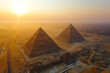 Aerial view showing the iconic Pyramids of Giza in Egypt during a beautiful sunset.