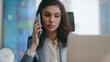 © stockbusters - Smiling manager answer call sitting luxury office close up. Woman talking phone.