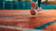 A girl sprints across the rubberized track of the gymnasium, her sneakers pounding against the surface as she pushes herself to reach her maximum speed