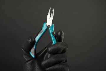 Sticker - Woman with bent nose pliers on dark background, closeup