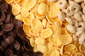 Different types of breakfast cereals as background, top view