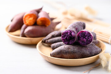 Wall Mural - Boiled purple and orange sweet potato on wooden plate