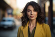 © 1by1step - portrait of a beautiful woman in a yellow blazer casual shoulder-length dark brown hair with highlights green eyes walking down the street blurry background bokeh effect, cityscape