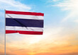 3D illustration of a Thailand flag extended on a flagpole and in the background a beautiful sky with a sunset